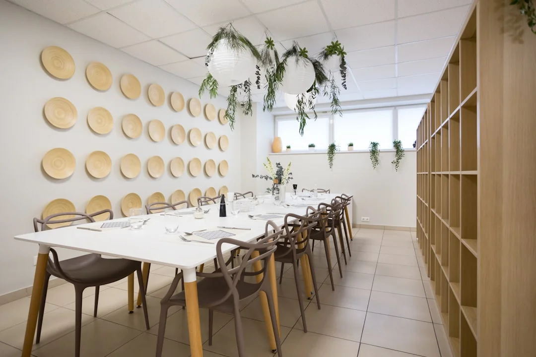 Intérieur de bureau spacieux et moderne avec cloisons vitrées, mobilier élégant et œuvres murales colorées.